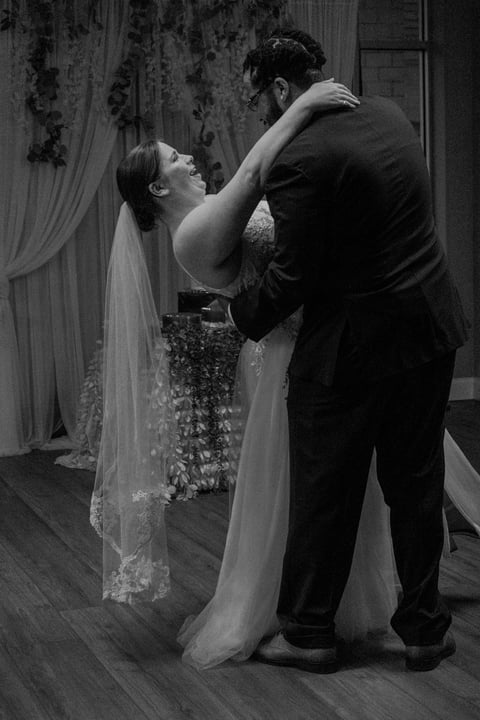 Black and white photograph of a bride and groom dancing together