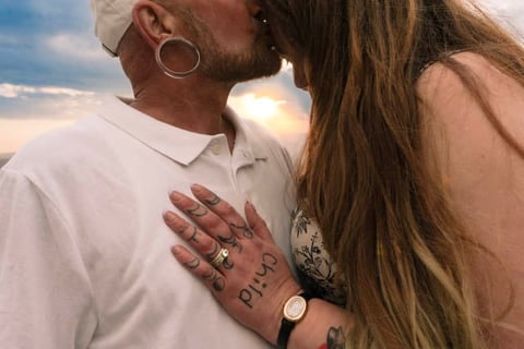 Two people kissing outdoors during sunset