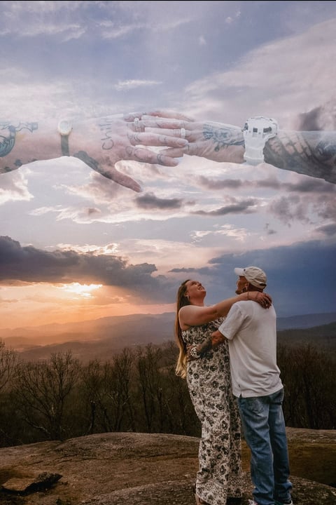 Couple embracing at sunset with artistic overlay of hands stacked above them against a cloudy sky and mountain landscape