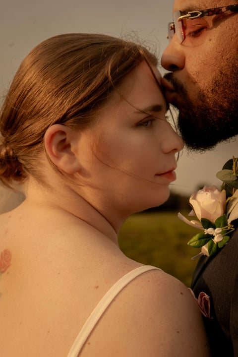 Couple in profile sharing a romantic moment near a white flower, intimate portrait shot