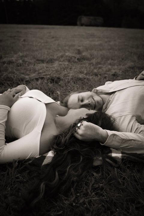 Black and white photo of a couple lying on grass