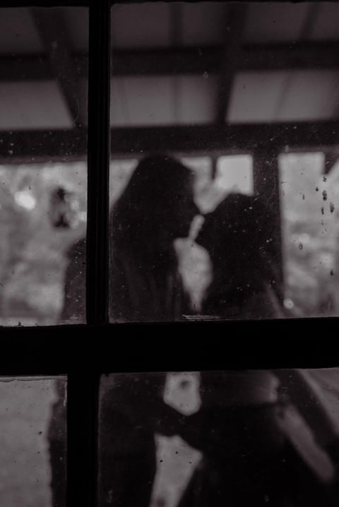 Silhouette of a person visible through a rain-covered window